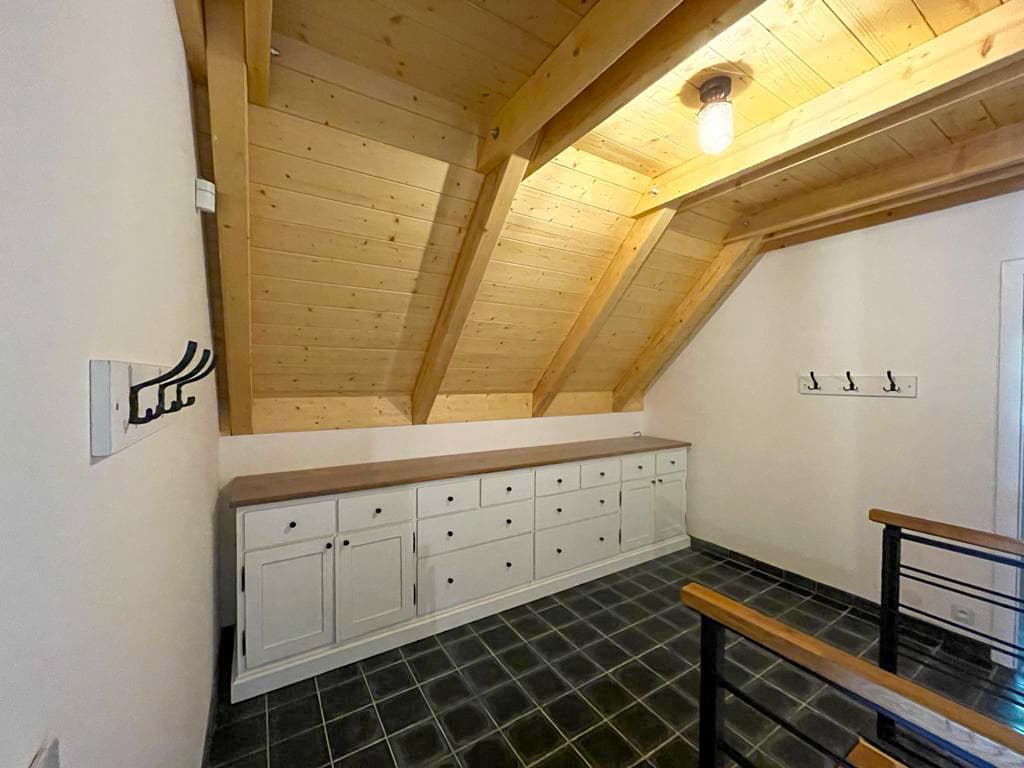 Dlouhá nízká komoda z masivu vyrobená na míru přímo pod dřevěnou šikminu v podkroví roubenky.