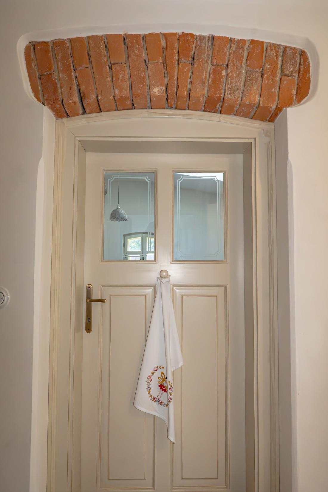 Elegantní interiérové dveře z masivu vybavené ozdobným pískovaným prosklením a mosaznou klikou.