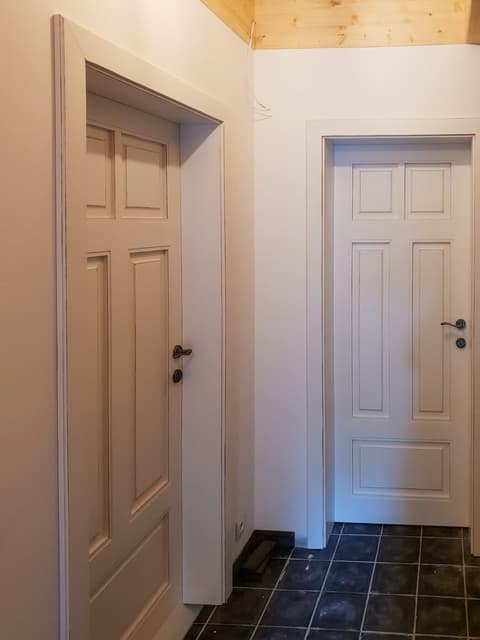 Elegantní bílé kazetové interiérové dveře z poctivého masivu v čistém nadčasovém designu na chodbě.