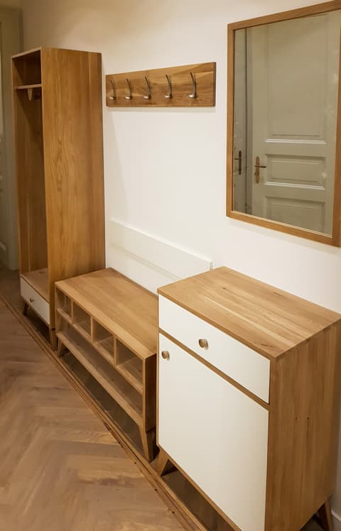 Komplexní předsíňová sestava z přírodního masivního dřeva obsahující otevřený botník, šuplíkovou komodu, šatní panel a zrcadlo.