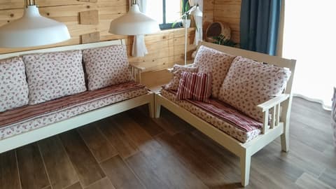 Sestava dřevěných lavic z masivu v bílé barvě doplněná o měkké vzorované polstrování pro pohodlné sezení.