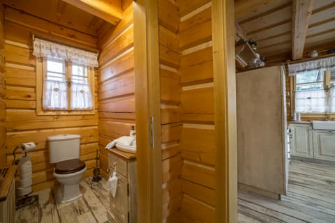 Dřevěná WC skříňka a umyvadlová skříňka z masivního dřeva v koupelně roubenky.