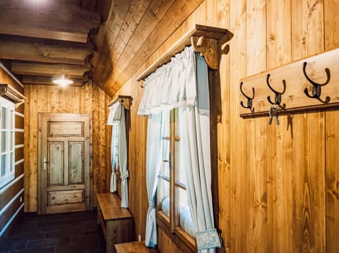 Útulná chodba s dřevěným obložením, tradičními dveřmi a venkovskými doplňky.