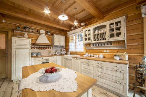 Selská kuchyňská linka z poctivého masivu s keramickým dřezem a velkým kuchyňským ostrůvkem v roubence.