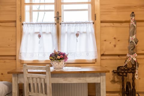 Detail dřevěného psacího stolku z masivu pod oknem s masivní garnýží v podkrovním pokoji.