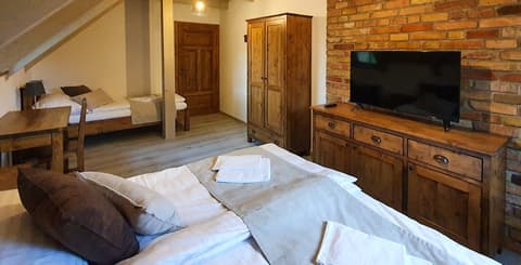 Podkrovní ložnice s manželskou postelí, šatní skříní a TV komodou z poctivého masivního dřeva.